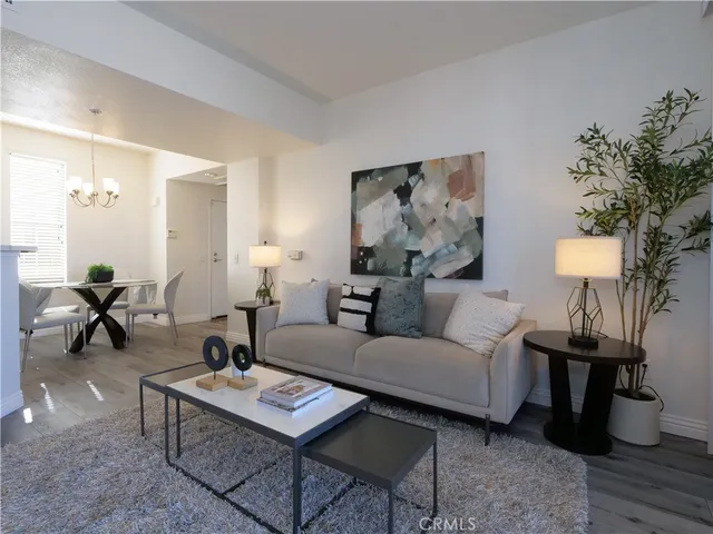 a living room with furniture a lamp paintings and a table