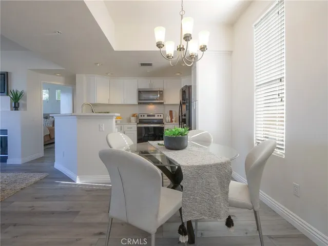 a view of a dining room with furniture a chandelier and wooden floor