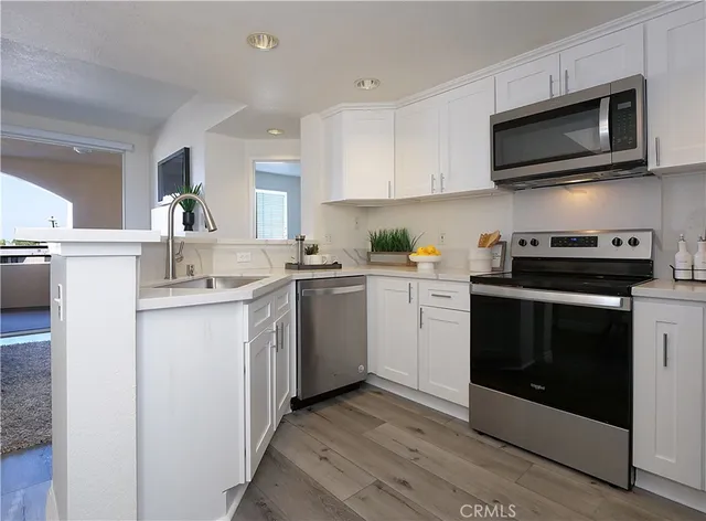 a kitchen with stainless steel appliances a stove microwave and sink