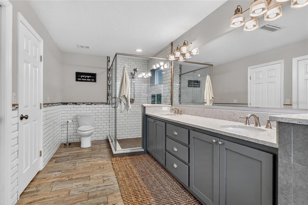 1795 Brumley Road Chuluota, FL 32766 - Photo 17 of 41 a spacious bathroom with a double vanity sink a large mirror and a shower