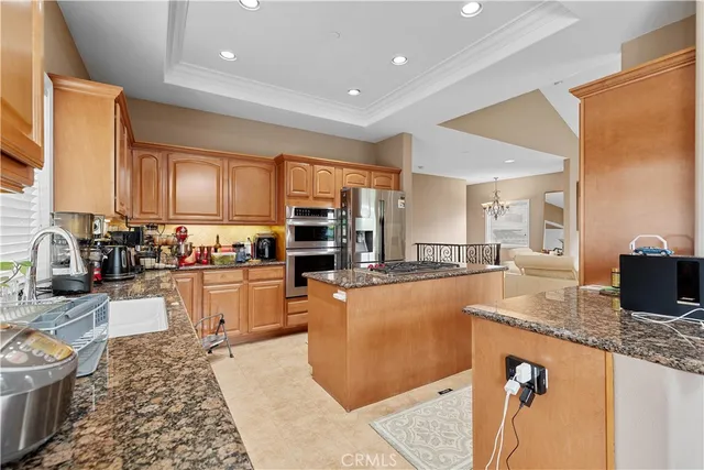 a kitchen with stainless steel appliances granite countertop a sink refrigerator stove and microwave