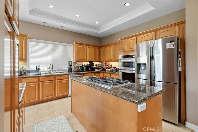 a kitchen with stainless steel appliances granite countertop a refrigerator a stove a sink and a microwave