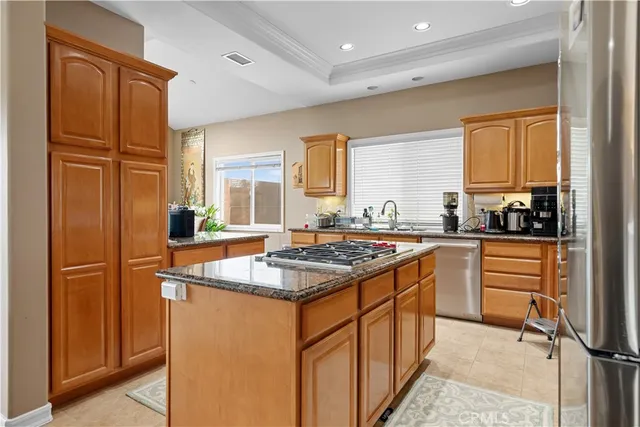 a kitchen with stainless steel appliances granite countertop a refrigerator a sink dishwasher a stove and a refrigerator