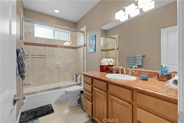 a bathroom with a bathtub shower sink vanity mirror and toilet