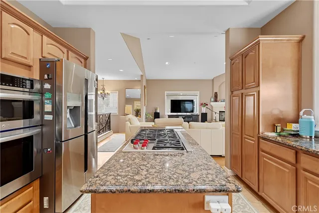 a kitchen with stainless steel appliances granite countertop a refrigerator and a stove