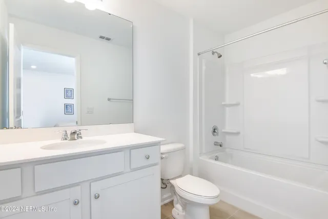 a kitchen that has a lot of cabinets in it with stainless steel appliances granite countertop a stove a sink a refrigerator and white cabinets