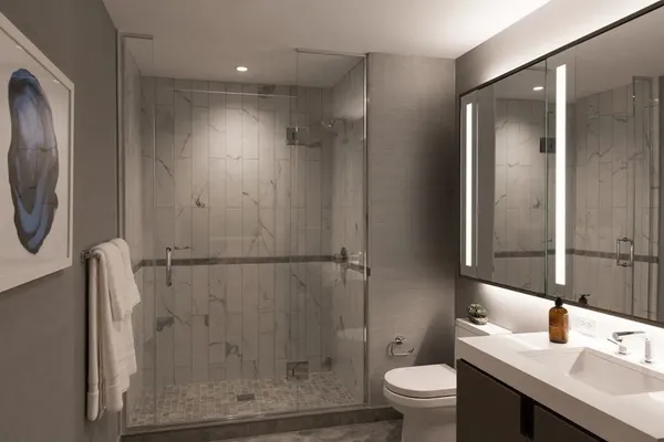 a bathroom with a granite countertop sink toilet and shower