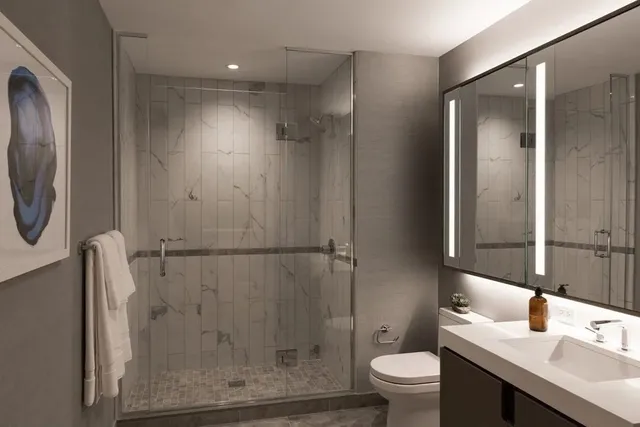 a bathroom with a granite countertop sink toilet and shower