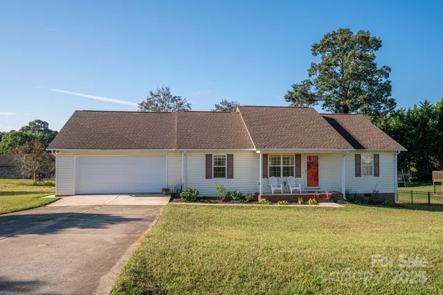 a front view of house with yard and trees in the background