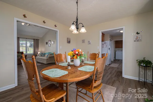 a dining room with furniture potted plants and wooden floor
