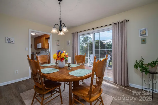 a dining room with furniture potted plants and wooden floor