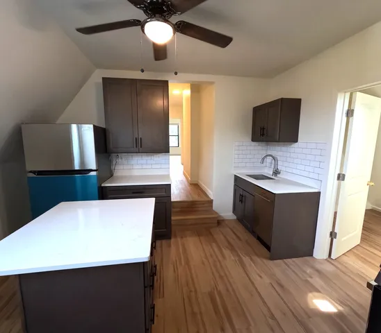 a living room with stainless steel appliances kitchen island granite countertop furniture and a flat screen tv