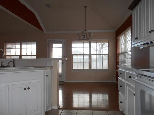 a kitchen with kitchen island granite countertop a stove a sink and a refrigerator with wooden floors