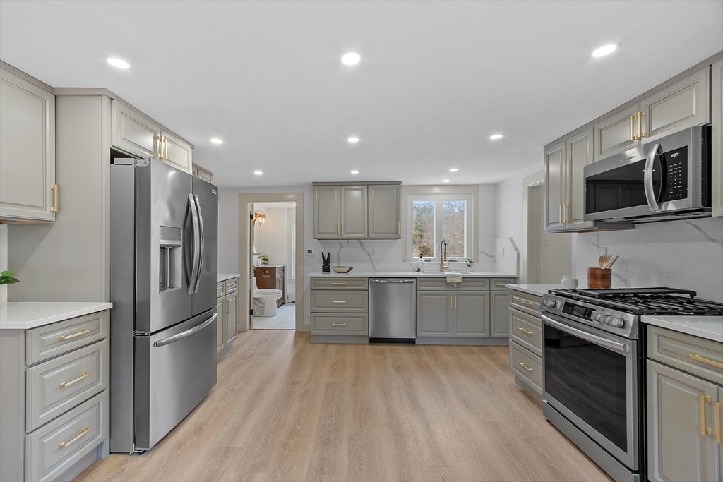 453 Main Street Northborough, MA 01532 - Photo 11 of 42 a large kitchen with stainless steel appliances granite countertop a stove a refrigerator and a microwave