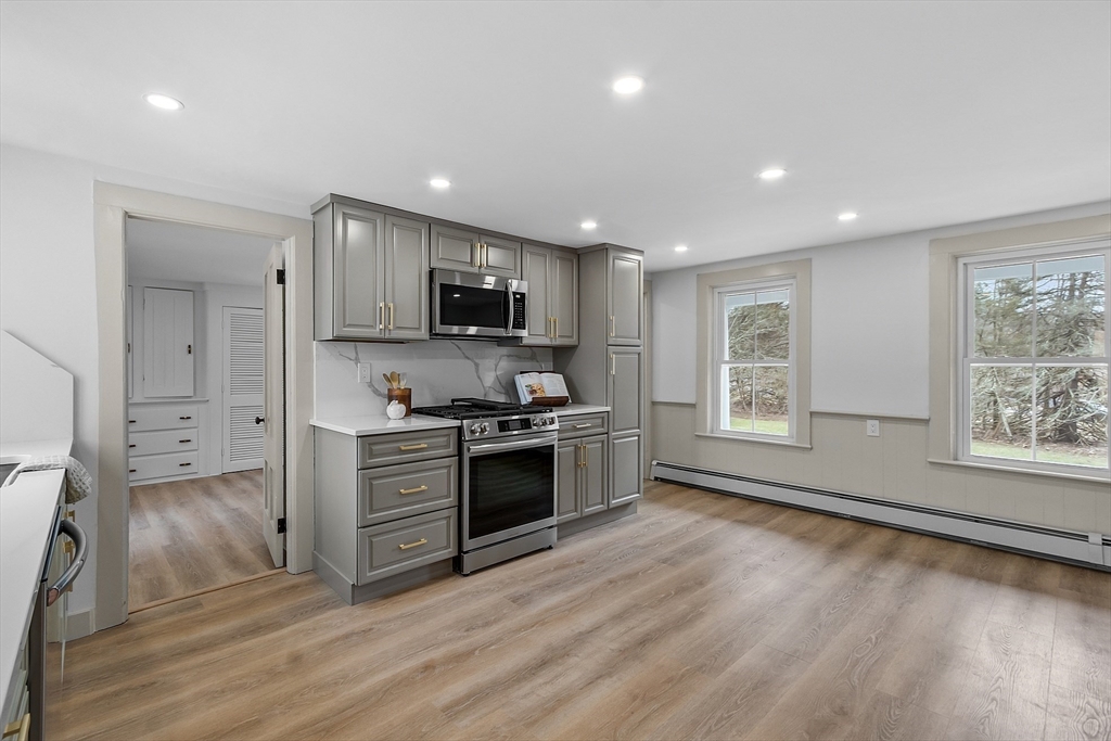 453 Main Street Northborough, MA 01532 - Photo 10 of 42 a large kitchen with stainless steel appliances granite countertop a stove a sink dishwasher and a microwave oven with wooden floor