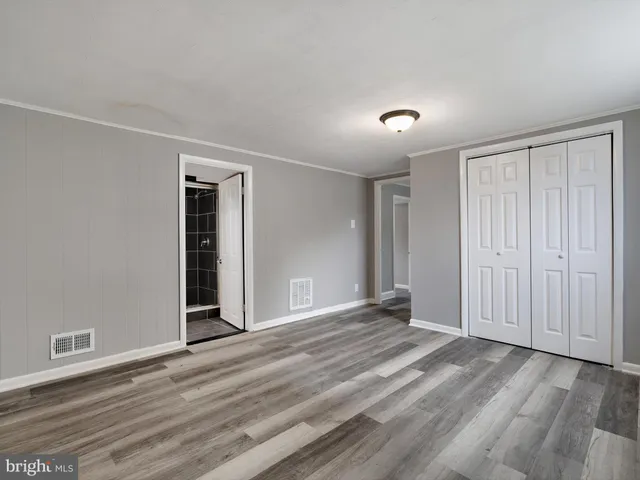 a view of an empty room with wooden floor