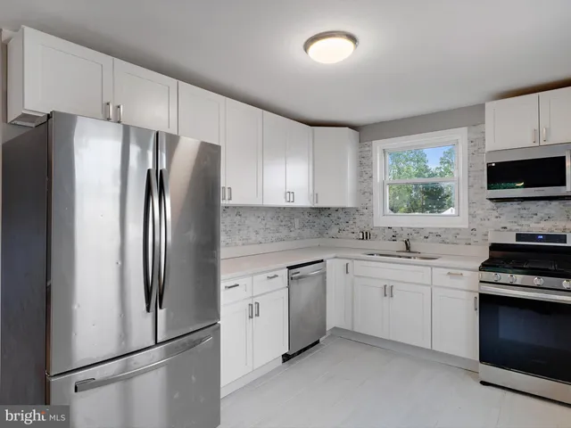 a kitchen with stainless steel appliances a refrigerator sink and microwave