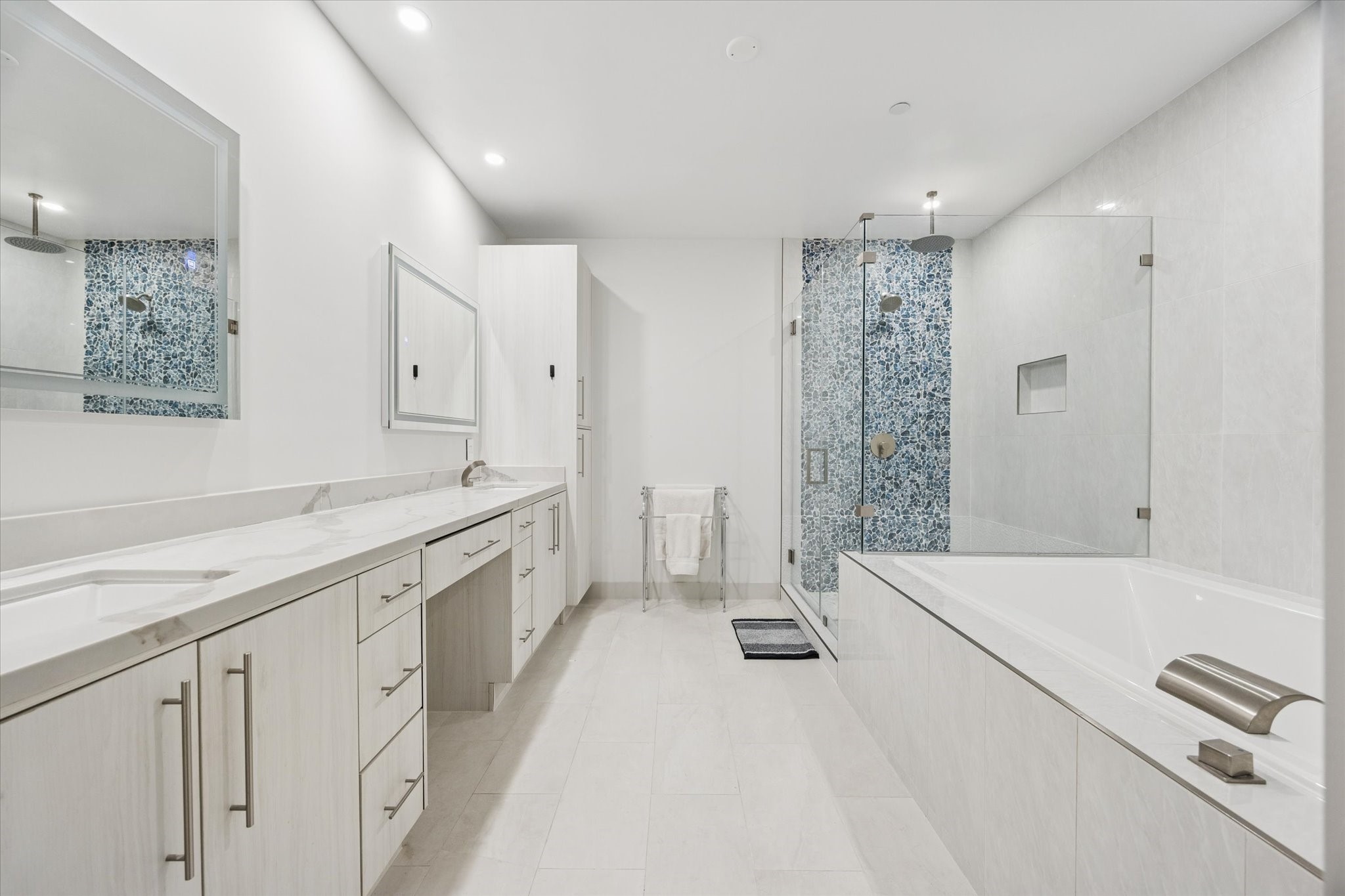 1600 Post Oak Boulevard, Unit 802 Houston, TX 77056 - Photo 10 of 19 The beautiful spa-like Primary Bathroom features tile floors, elongated vanity with Quartz countertops, LED mirrors, dual sinks and knee-space cut out; soaking tub and separate oversized glass-framed shower with tile accent wall and dual showerheads (one of which is a rain showerhead).