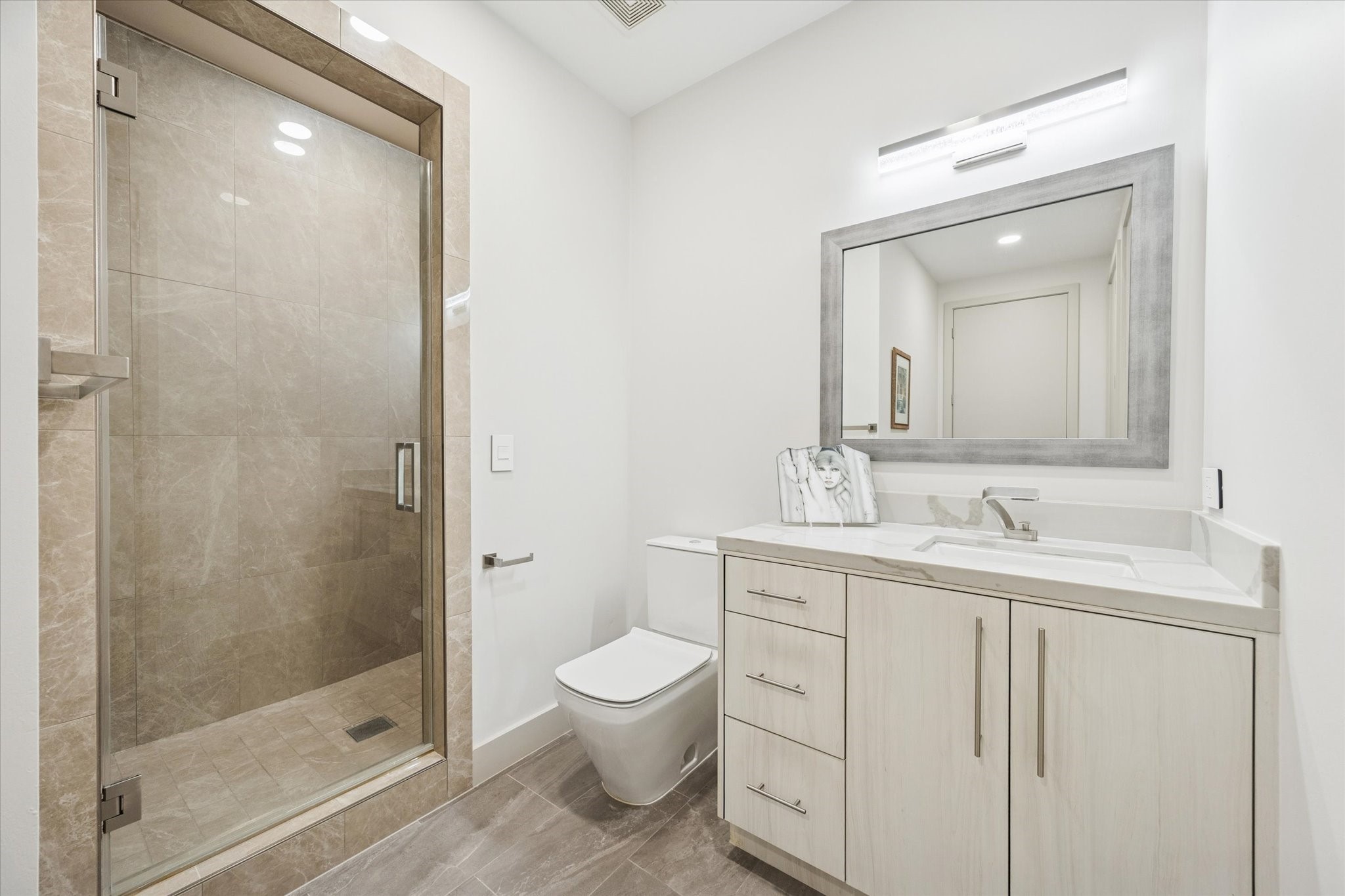 1600 Post Oak Boulevard, Unit 802 Houston, TX 77056 - Photo 15 of 19 Secondary Bathroom #1 features a sink vanity with Quartz countertops and glass-framed shower.
