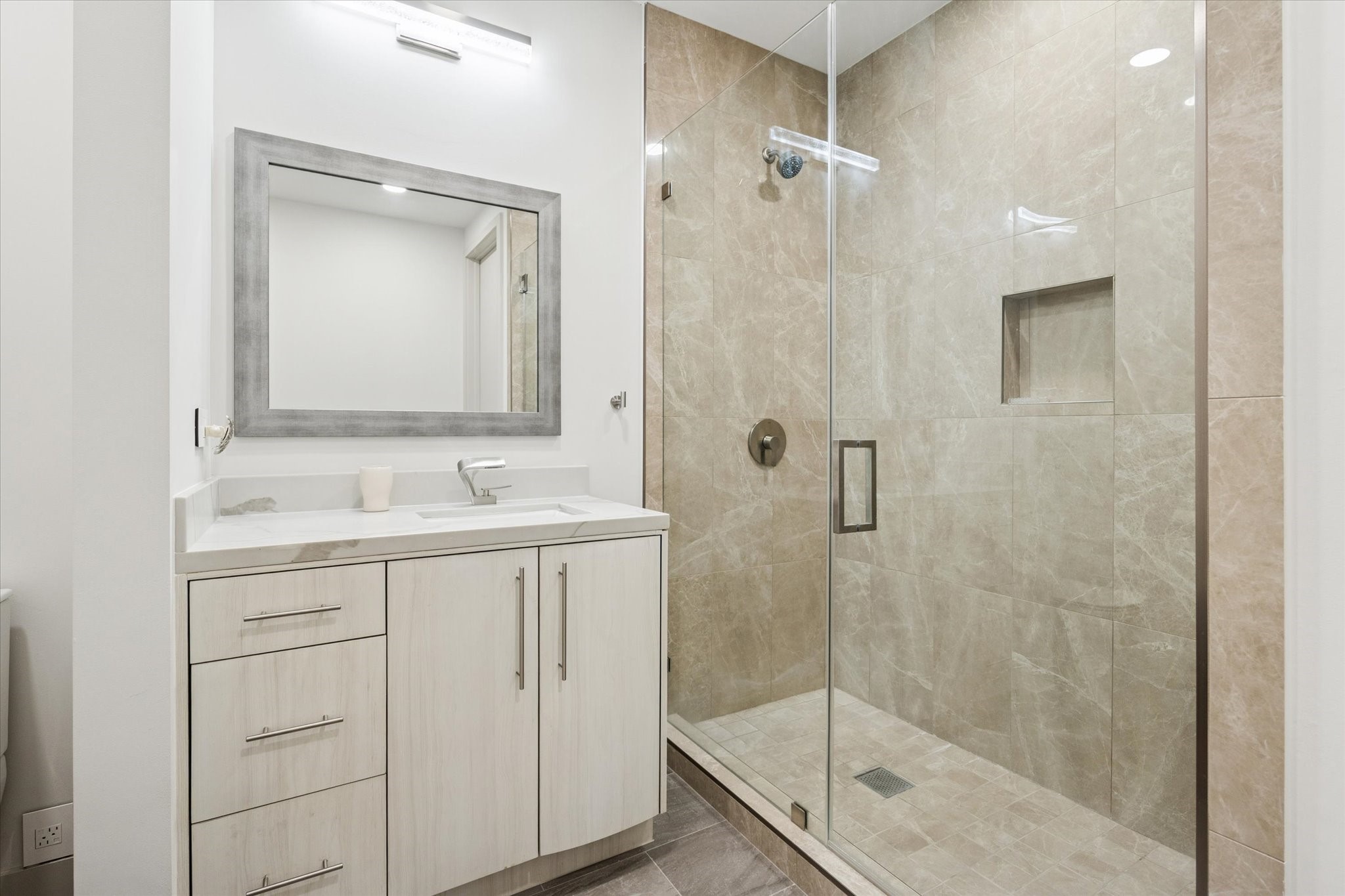 1600 Post Oak Boulevard, Unit 802 Houston, TX 77056 - Photo 17 of 19 Secondary Bathroom #2 features a sink vanity with Quartz countertops and glass-framed shower.