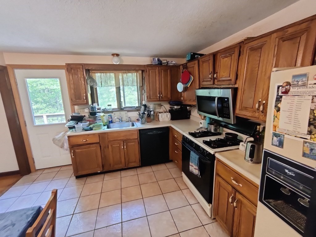 439 Massapoag Avenue Sharon, MA 02067 - Photo 6 of 22 a kitchen with a stove a sink dishwasher and a refrigerator