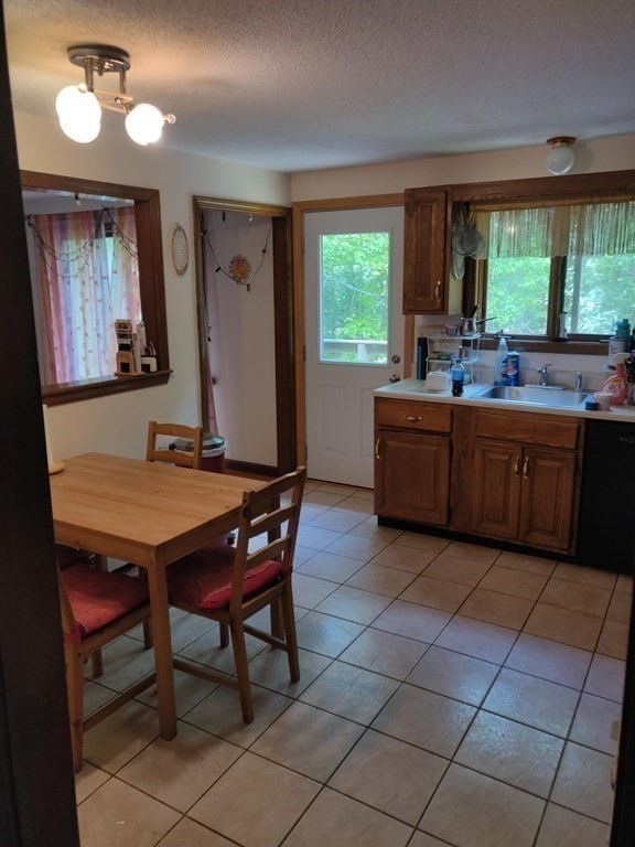439 Massapoag Avenue Sharon, MA 02067 - Photo 7 of 22 a room with a wooden table chairs and a large window