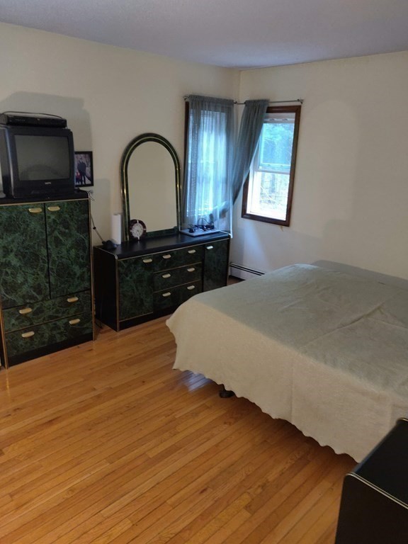 439 Massapoag Avenue Sharon, MA 02067 - Photo 9 of 22 a bedroom with a bed and a dresser with mirror