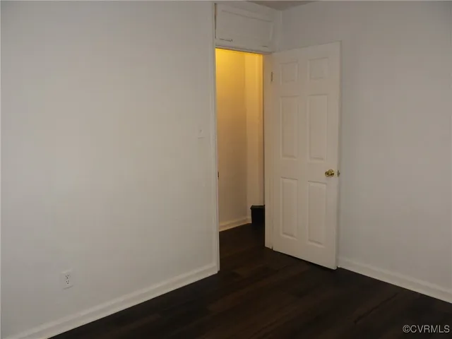 an empty room with wooden floor and a window