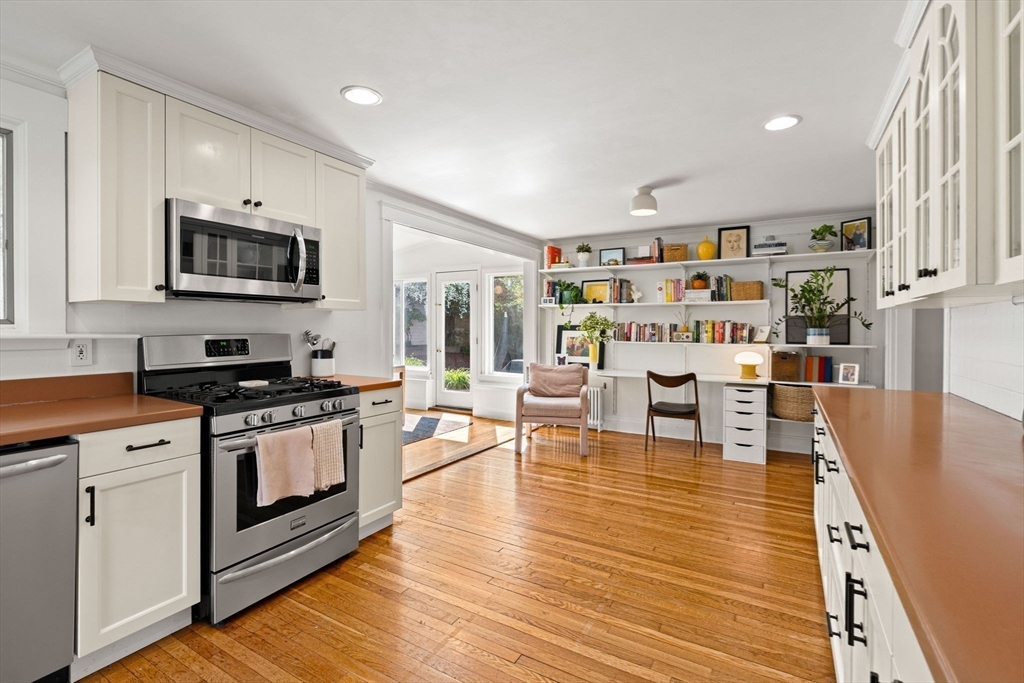 34 Avalon Road Milton, MA 02186 - Photo 19 of 42 a kitchen with stainless steel appliances granite countertop a stove top oven a sink a dining table and chairs with wooden floor