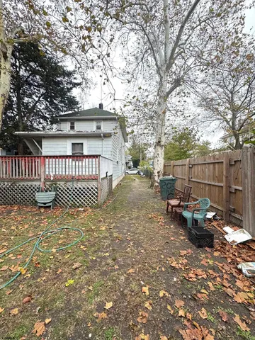 a view of a backyard with a large tree and wooden fence