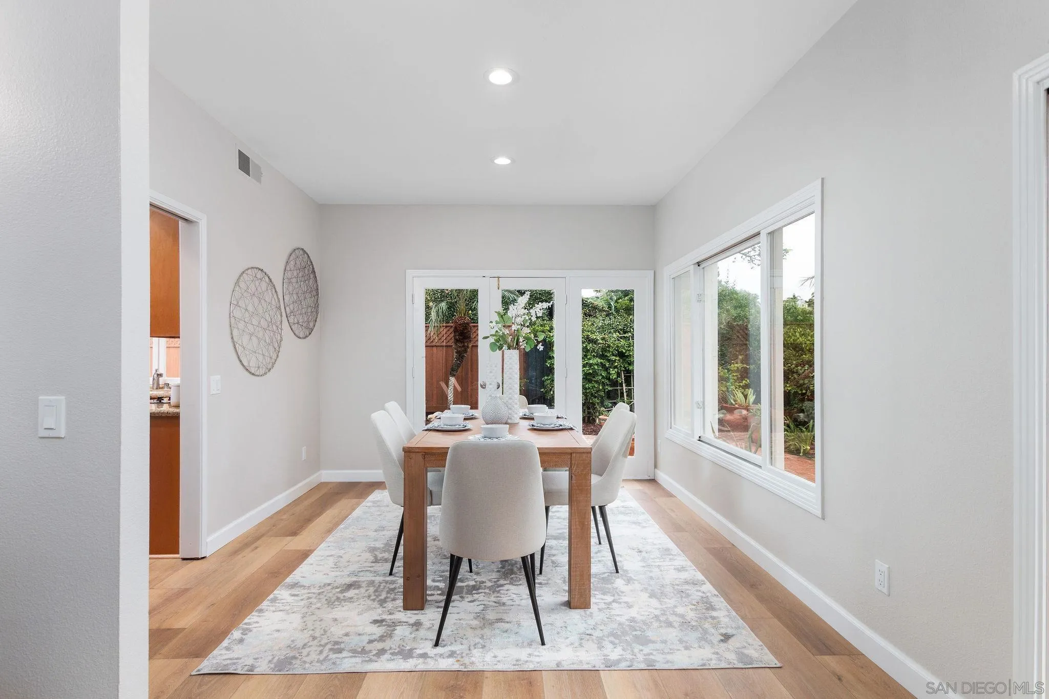 1863 Caminito Quintero La Jolla, CA 92037 - Photo 6 of 27 a dining room with chandelier and wooden floor