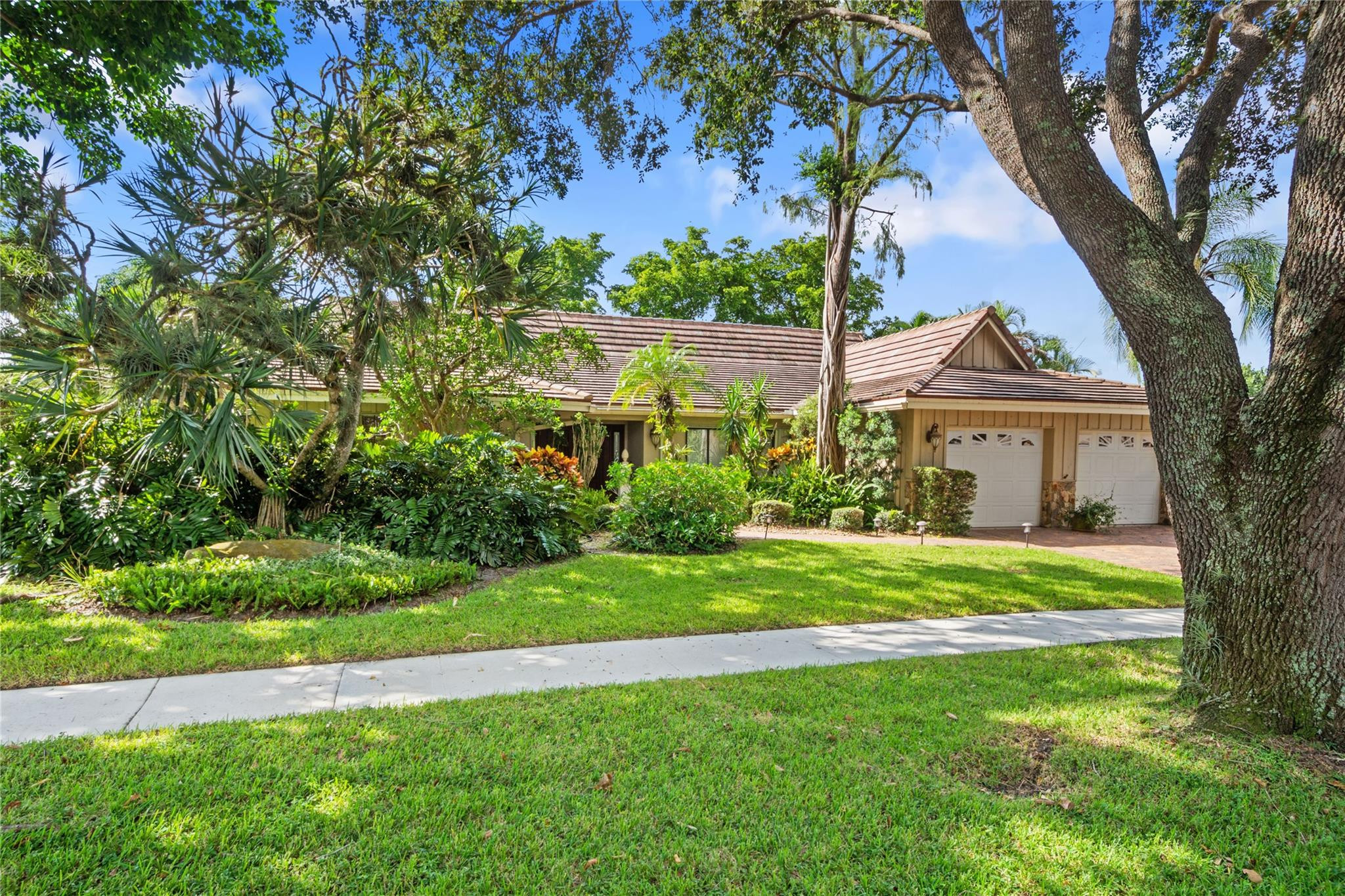 6832 Viento Way Boca Raton, FL 33433 - Photo 29 of 31 a front view of a house with a garden and trees