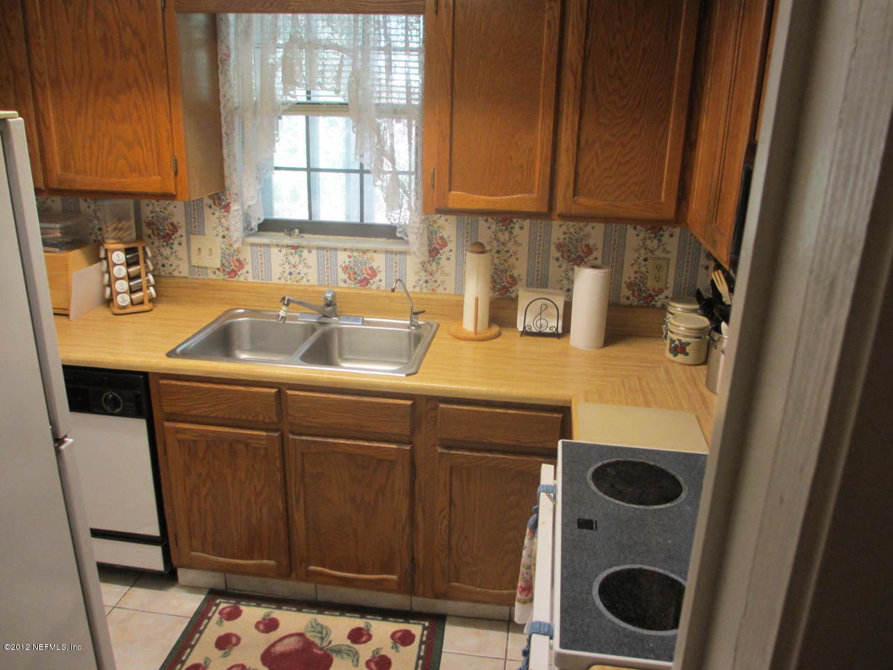 1303 Kettering Way Orange Park, FL 32073 - Photo 14 of 24 a kitchen with a sink a refrigerator and cabinets