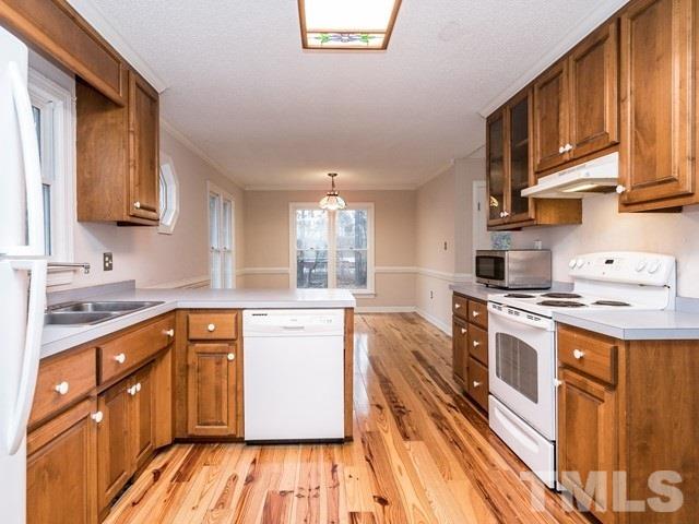 7201 Cedric Drive Raleigh, NC 27603 - Photo 11 of 25 a kitchen with stainless steel appliances granite countertop a stove a sink dishwasher and a refrigerator with wooden cabinets