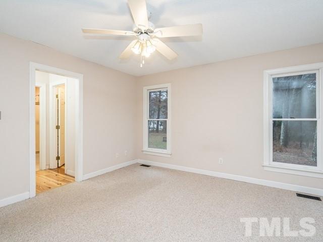 7201 Cedric Drive Raleigh, NC 27603 - Photo 14 of 25 an empty room with windows and fan