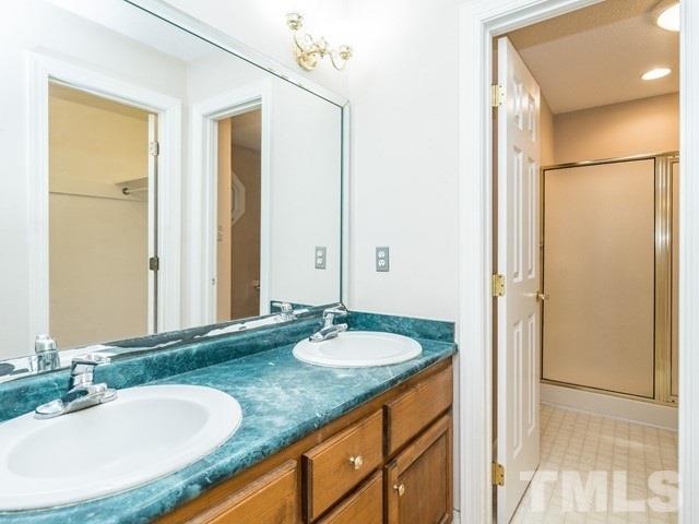 7201 Cedric Drive Raleigh, NC 27603 - Photo 16 of 25 a bathroom with a granite countertop sink and a mirror