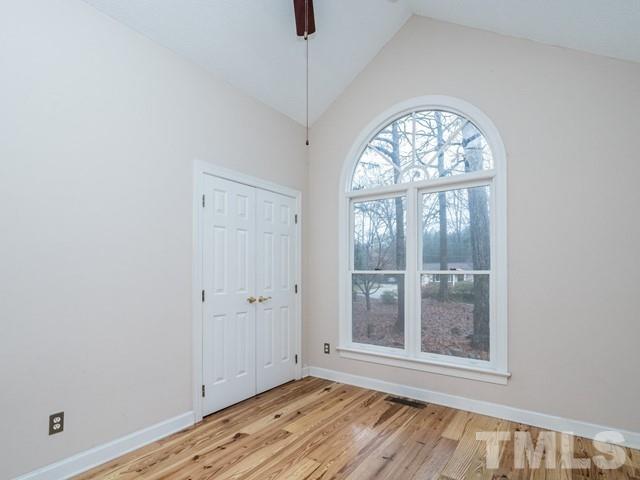 7201 Cedric Drive Raleigh, NC 27603 - Photo 18 of 25 an empty room with wooden floor a ceiling fan and windows