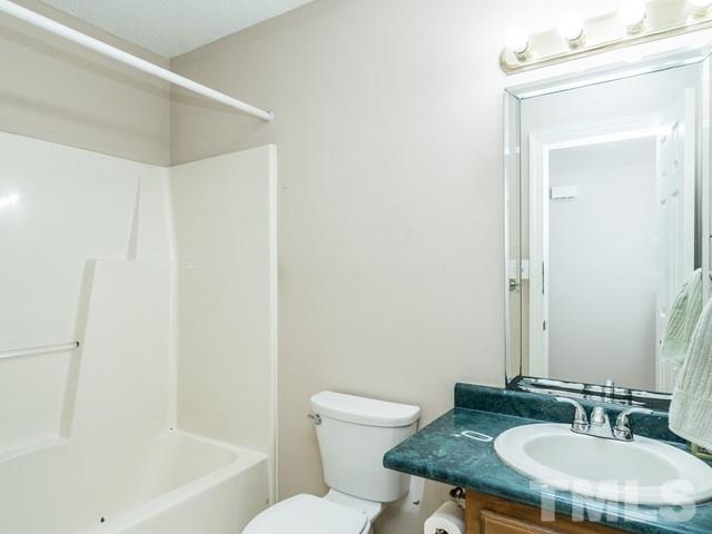 7201 Cedric Drive Raleigh, NC 27603 - Photo 19 of 25 a bathroom with a granite countertop sink toilet and a mirror