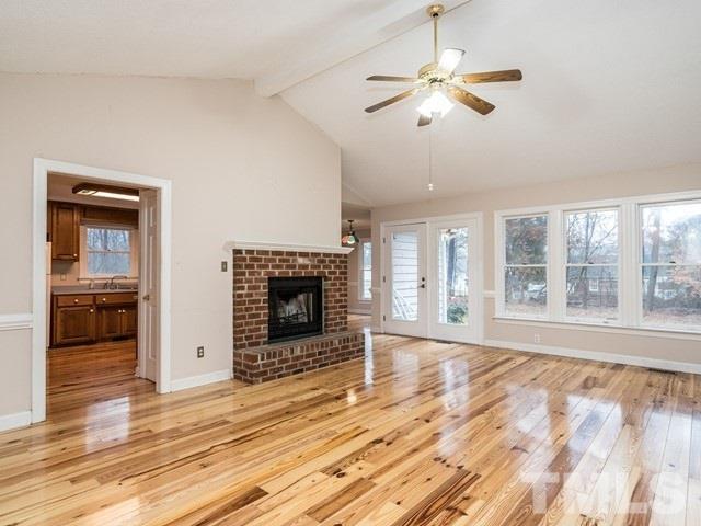 7201 Cedric Drive Raleigh, NC 27603 - Photo 3 of 25 a view of an empty room with wooden floor fireplace and a window