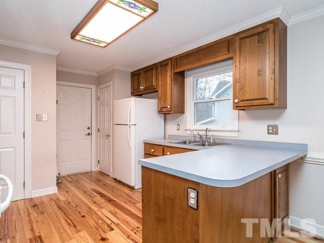 7201 Cedric Drive Raleigh, NC 27603 - Photo 8 of 25 a kitchen with a sink a refrigerator and cabinets