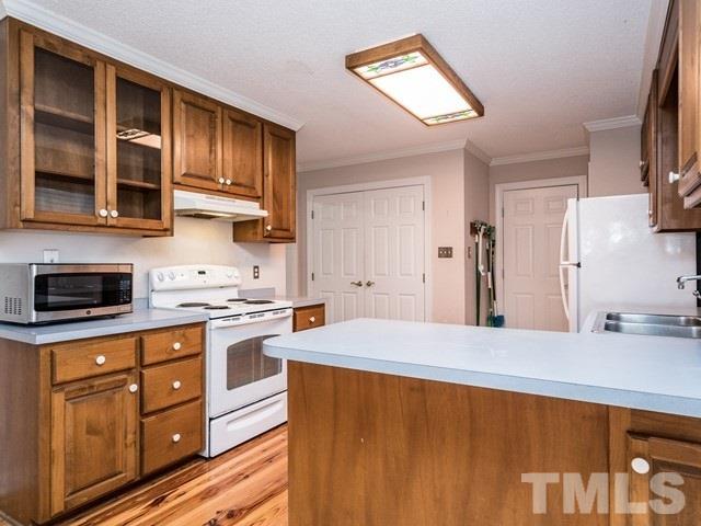 7201 Cedric Drive Raleigh, NC 27603 - Photo 10 of 25 a kitchen with stainless steel appliances a stove refrigerator sink and cabinets