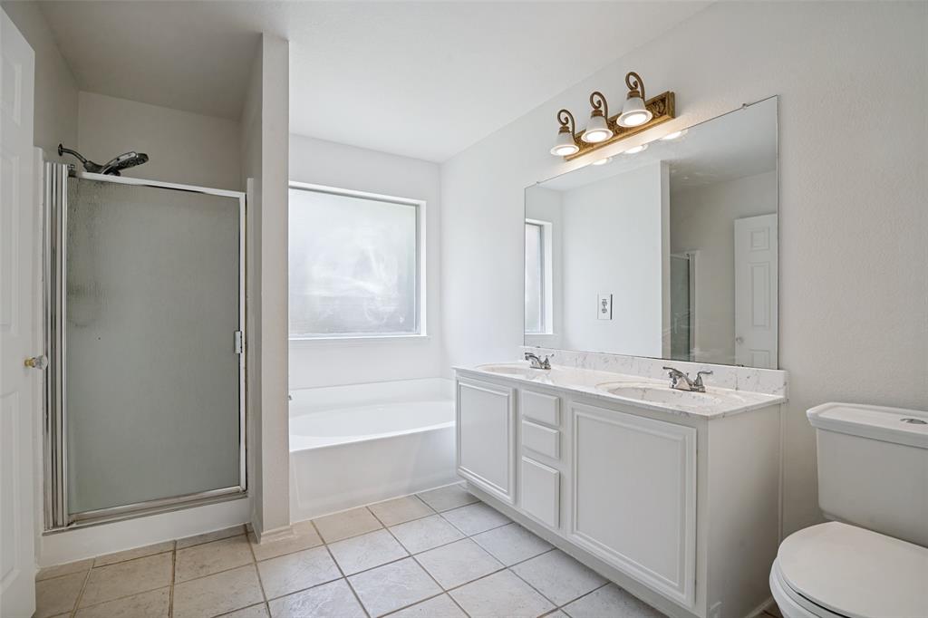 3111 Creekside Drive Sachse, TX 75048 - Photo 17 of 25 Bathroom featuring a dual-sink vanity with a light-toned countertop, a full-width mirror, and a three-light fixture