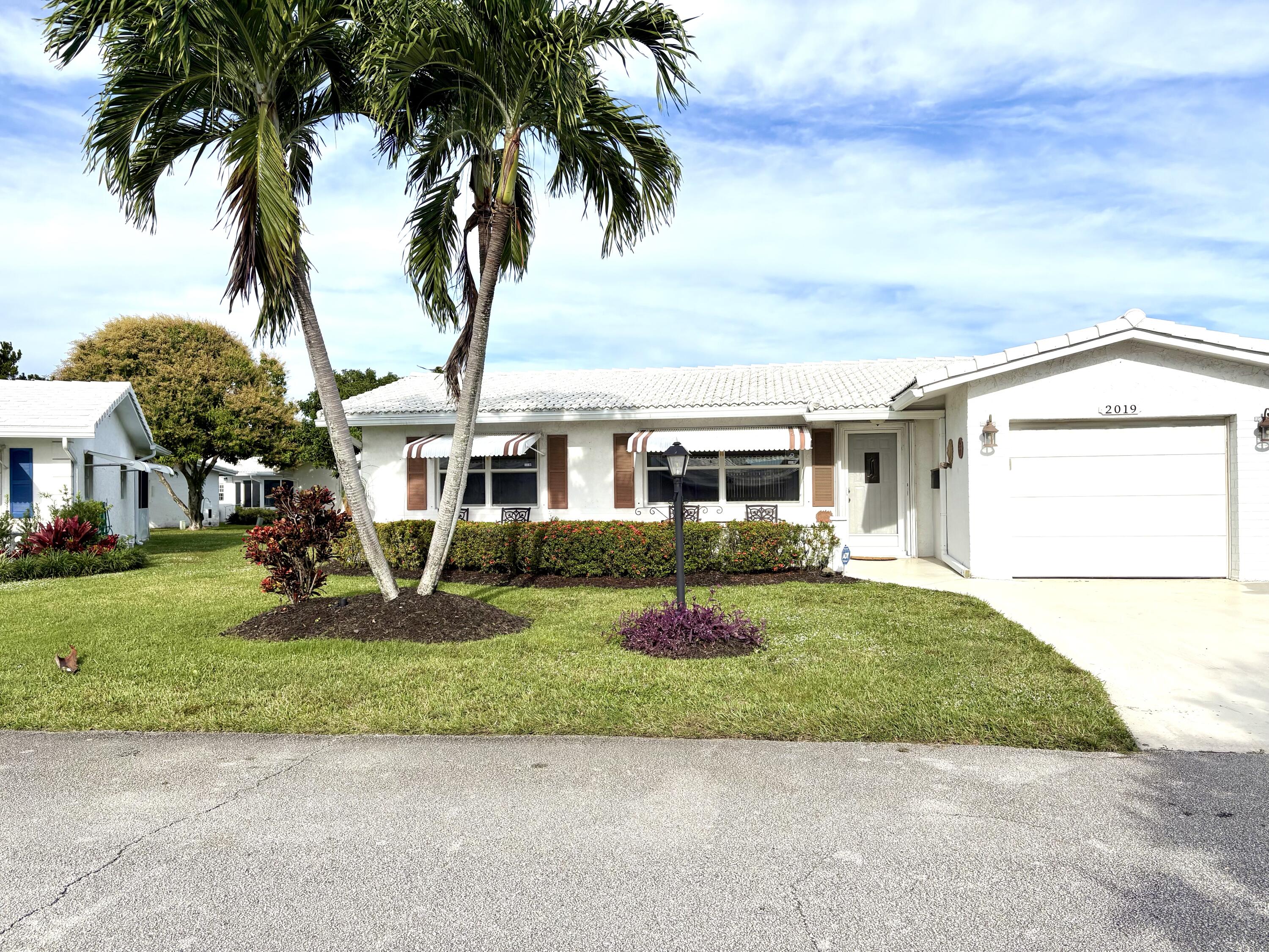 a front view of a house with a garden and yard