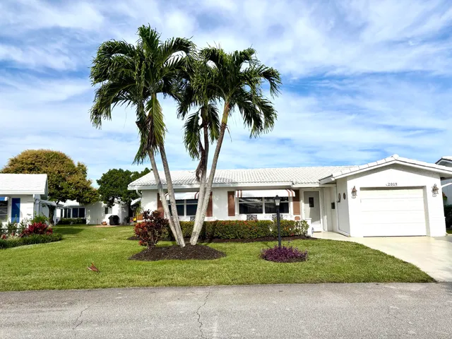 a front view of a house with a garden and a garage