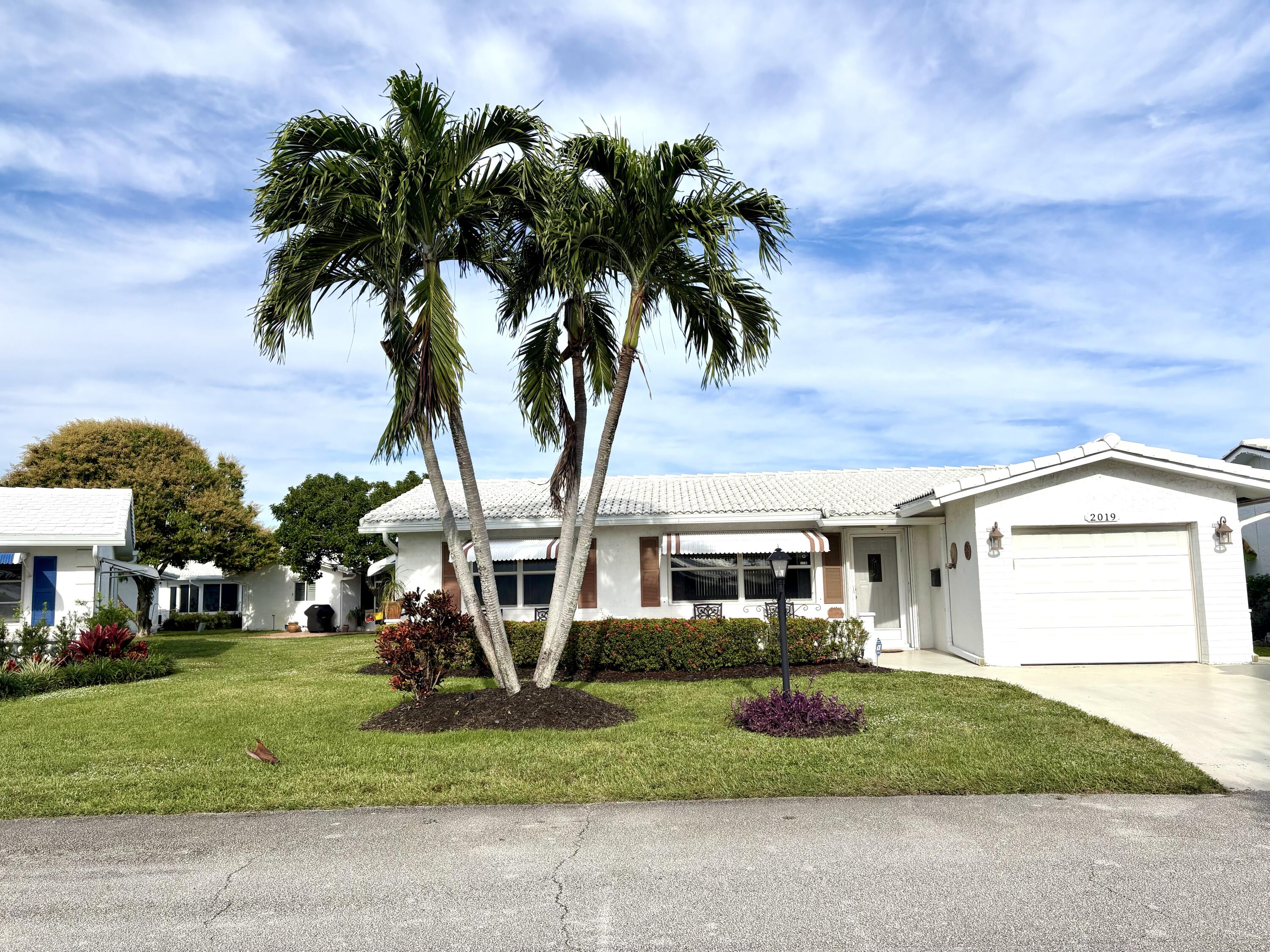 2019 Southwest 18th Drive Boynton Beach, FL 33426 - Photo 3 of 17 a front view of a house with a garden and a garage