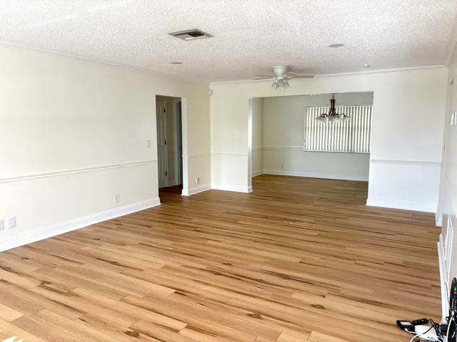 a view of empty room with wooden floor
