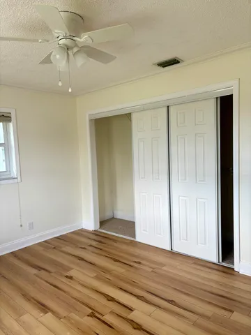 a view of a livingroom with wooden floor and a ceiling fan