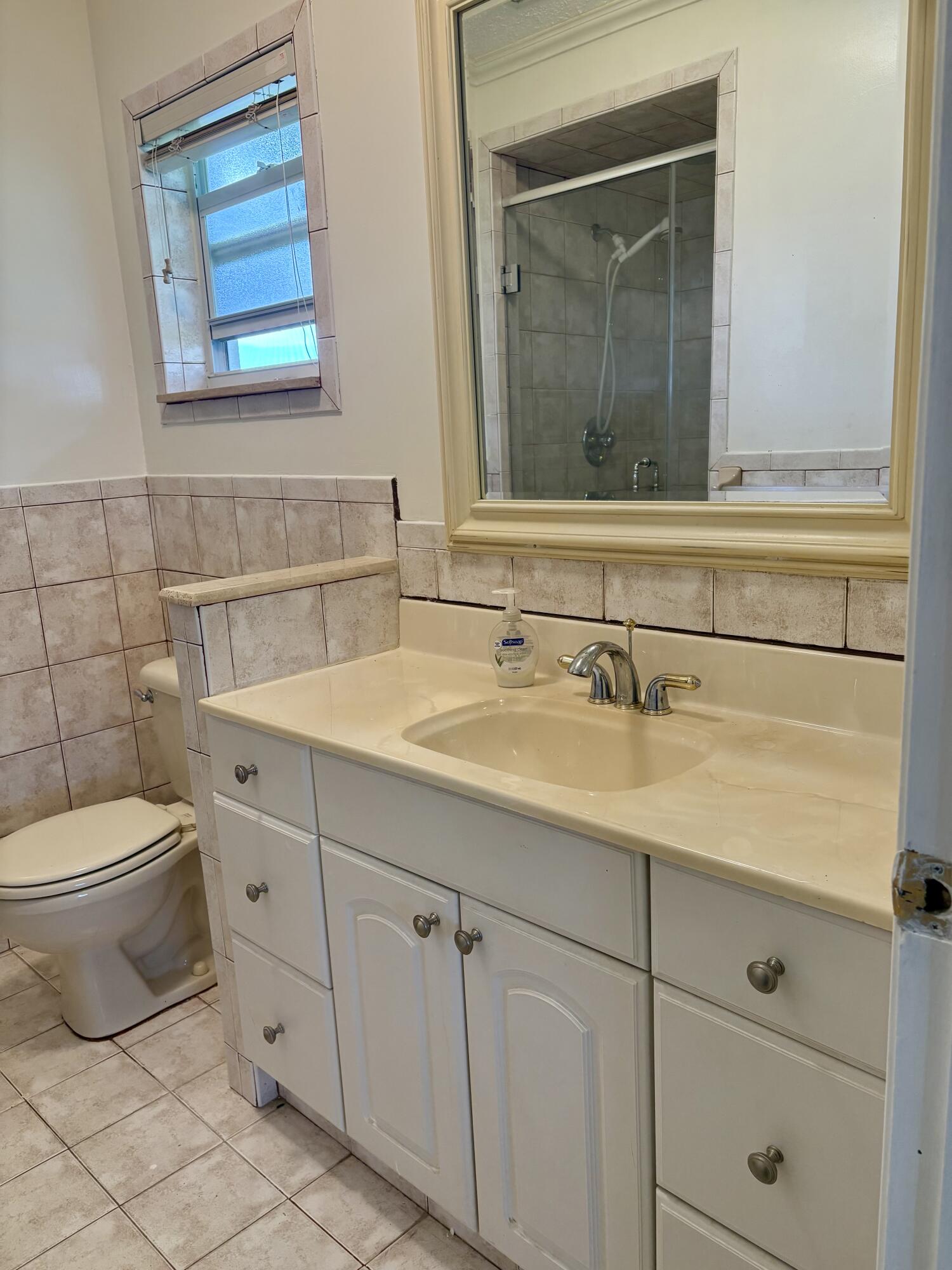 2019 Southwest 18th Drive Boynton Beach, FL 33426 - Photo 10 of 17 a bathroom with a toilet sink and mirror
