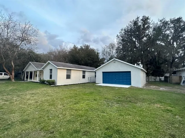 a front view of a house with a garden and trees