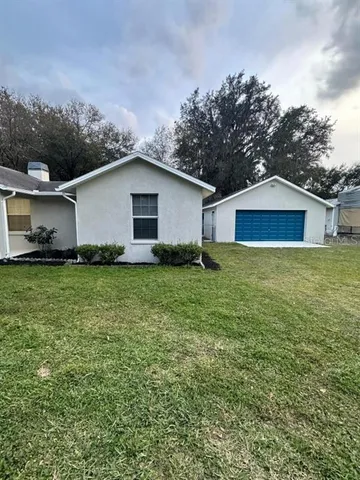 a white house with a small yard and wooden fence